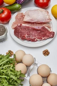 A table with meat eggs and vegetables on it Stock Photos