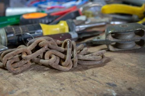 Table of a mechanical and electrician workshop, with an old chain and another Stock Photos