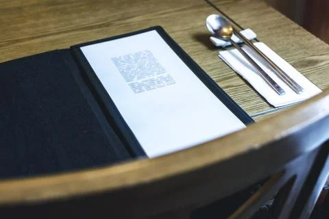 Table with a menu and silverware Stock Photos