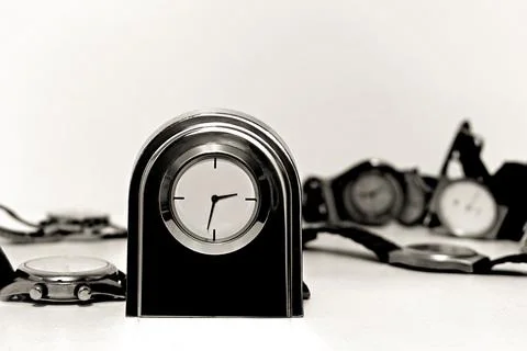 Table metal clock with minimalistic dial on wristwatch background Stock Photos