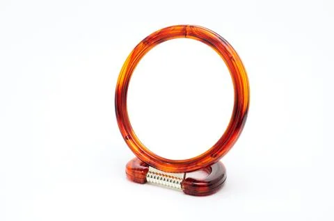 Table mirror in amber frame on a white background Stock Photos