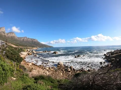 Table Mountain with Ocean, Rocks, and Cloudy Sky Stock Photos