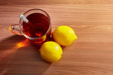 On the table a mug of tea with a spoon with lemons top view Stock Photos