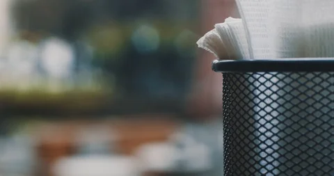 A table napkin is on the table in the cafe. People passing by Stock Footage 106216595