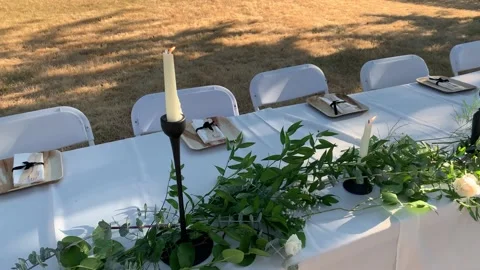 Table neatly set up outside for guests during a wedding reception on a sunny Видео 220241224