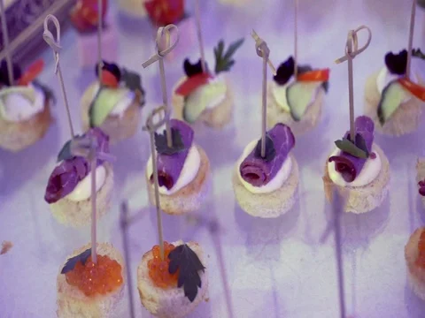 The table is nicely covered with appetizers with meat and caviar on bread Video stock 80949312