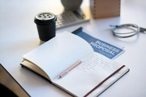 Table, notebook or business proposal with coffee in office, to do list or Stock Photos