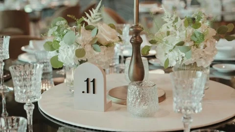 Table Number Sign and White Floral Centerpiece on Wedding Reception Table Stock Footage 343697736