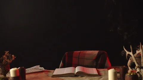 Table with open book, candles and magic ingredients 動画素材 125838833