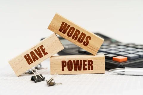 On the table is a pen, a calculator and small wooden blocks with the inscript Stock Photos