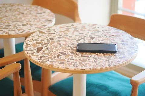 Table with a phone on it in a cafe setting. lost smart phone concept Stock Photos