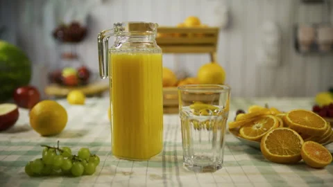 Table with pitcher of juice, empty glass and sliced oranges, tracking shot Stock Footage 341228324