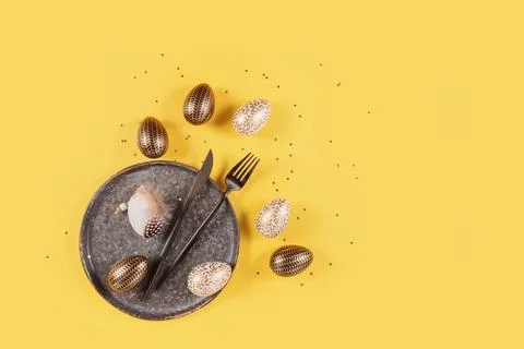 Table place setting and festive easter decor on yellow background Foto stock