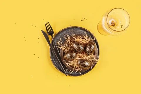Table place setting and festive easter decor on yellow background Stock Photos