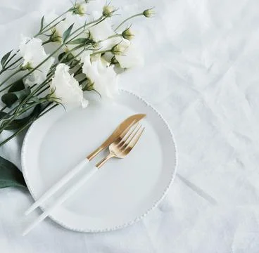 Table place setting and white flowers top view.  Space for text.  Holiday, birth Stock Photos