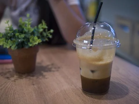 On table a plastic cup with Cold Brew Coffee gleams, ready to refresh. Cold Brew Stock Photos