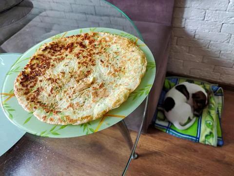 On the table on a plate lies a flatbread made at home with one's own hands Stock Photos