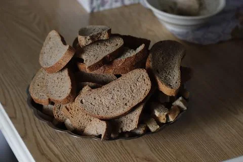On the table is a plate with slices of black bread crackers. Stock Photos