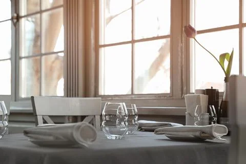 Table with plates and empty glasses in restaurant Stock Photos