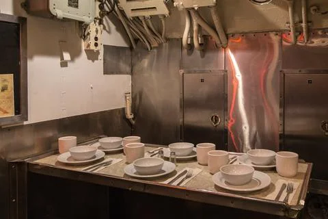 A table with plates and silverware is set up in a kitchen Stock Photos