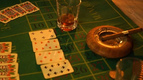 Table with playing cards, whiskey, cigar and weapons. Cowboy still life. Stock Footage 107539740