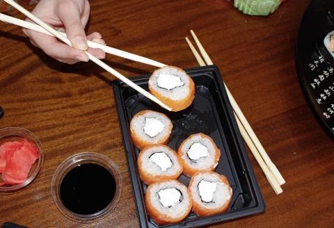 On the table is a portion of sushi rolls with ginger and soy sauce next to it Stock Photos