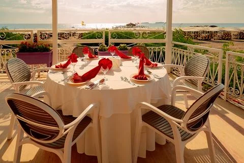 Table is prepared for dinner with elegant napkins and utensils. The sea and s Stock Photos