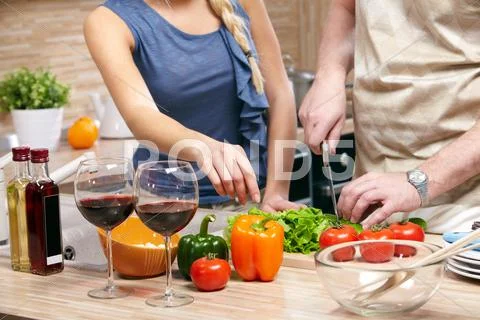A table with products and a cooking couple by it Stock Photos
