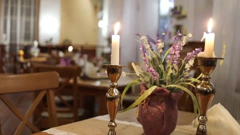 Table in restaurant decorated with two candles and Stock Footage 299636549
