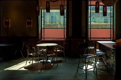 Table at a restaurant with sunlight streams through the Large windows, cast.. Stock Photos
