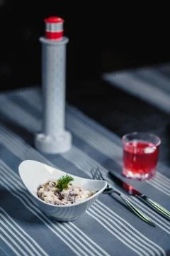 Table in the restaurant. On the table is a salad in a white plate, a knife, a Stock Photos