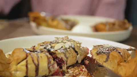 At the table in the restaurant, there are two large, round, white plates with Stock Footage 148252207