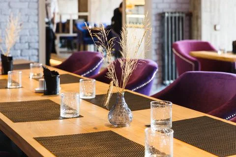 Table in the restaurant on which there are empty glasses and a vase, serving Stock Photos