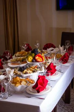 The table in the room is set in red tones with food for the holiday Stock Photos