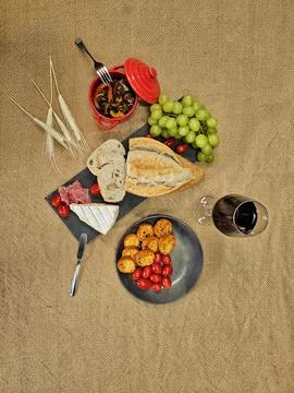 Table with rustic bread, brie cheese and fresh fruit Stock Photos