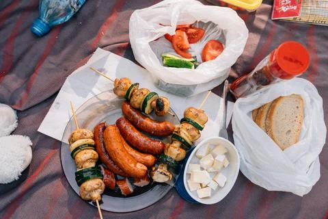 A table scape of summer picnic table with grilled sausages, mushrooms and Stock Photos