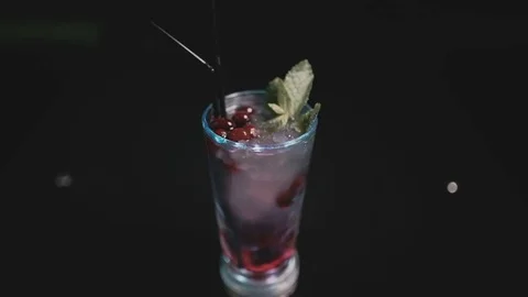 On the table is a scarlet cocktail Stock Footage 77342122
