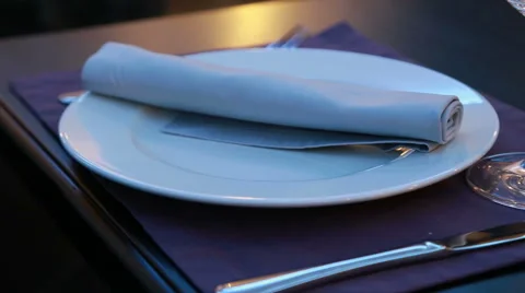 Table served for a restaurant dinner with plate fork knife and wineglass Stock Footage 48619910