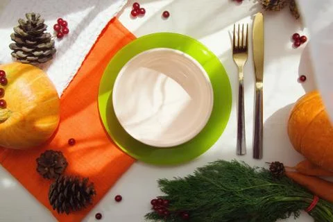 Table server with autumn composition. Cutlery, plate, pumpkin, red berries Stock Photos
