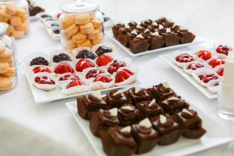 A table is serviced with white dishes with sweets Stock Photos