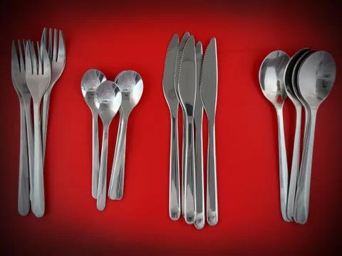 Table serving-knife,spoon,fork on red backdrop. Stock Photos