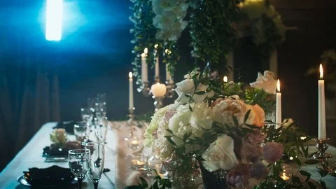 A table set with black arrows with food, wine glasses, flower vases Stock Footage 97718761