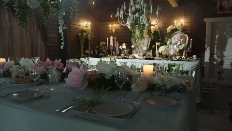 A table set with black arrows with food, wine glasses, flower vases Stock Footage 97720122