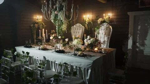A table set with black arrows with food, wine glasses, flower vases Stock Footage 97720605