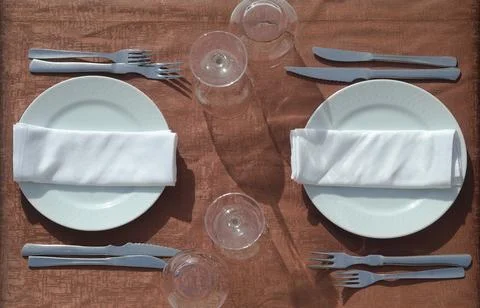 Table set with brown tablecloth, plates and glasses Stock Photos