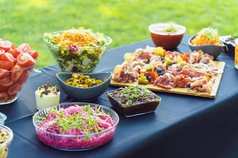 A table is set with delicious snacks prepared for a buffet in the garden. A Stock Photos