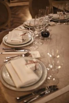 Table set for a dinner. white tablecloth and cutlery. muffled light Foto stock