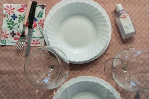 Table set up with dinnerware and silverware, ready for a meal. with disinfectant Stockfoto's