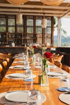 Table set for an event party with rose flower on table in vertical. Stock Photos