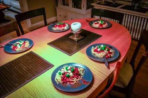 Table set with five plates of spaghetti, tomato sauce, mozarella and basil Stock-Fotos
